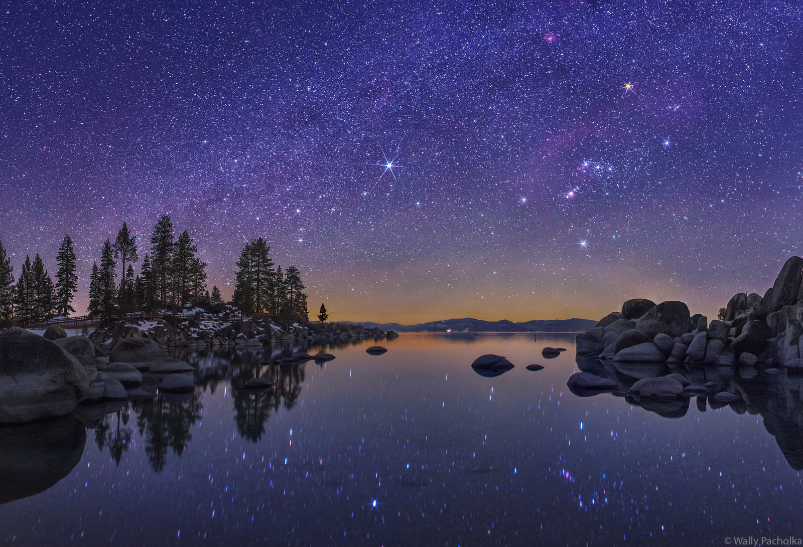 The winter constellations grow brightly over the serene Sand Harbor in Lake Tahoe.